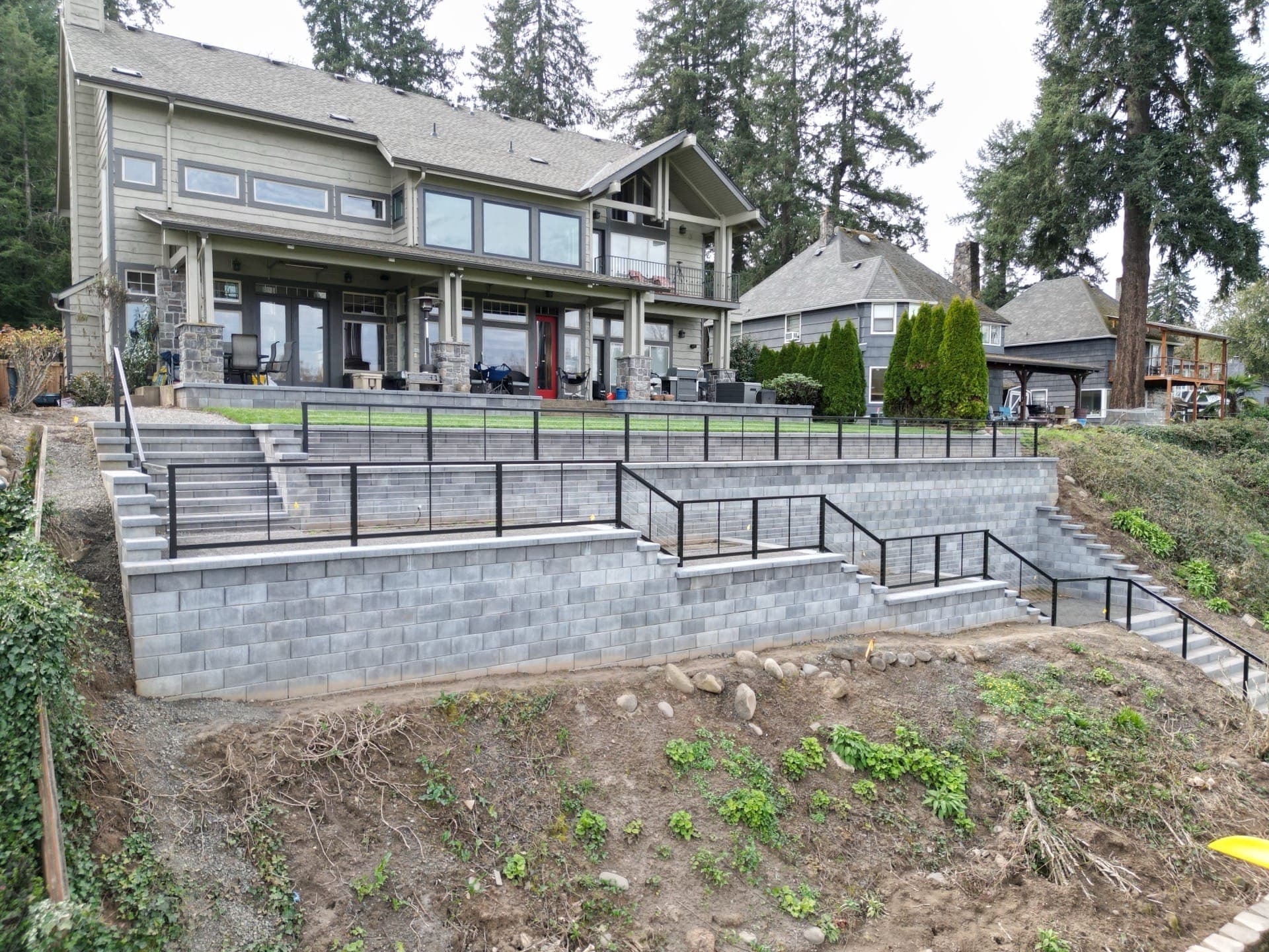 Engineered riverfront retaining wall reclaiming usable lawn above the Willamette River in West Linn, Oregon
